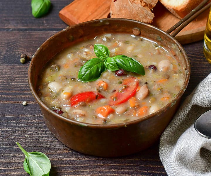 a bowl of soup with vegetables and herbs