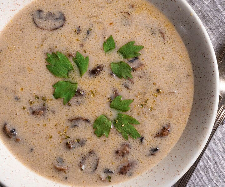 a bowl of soup with parsley on top
